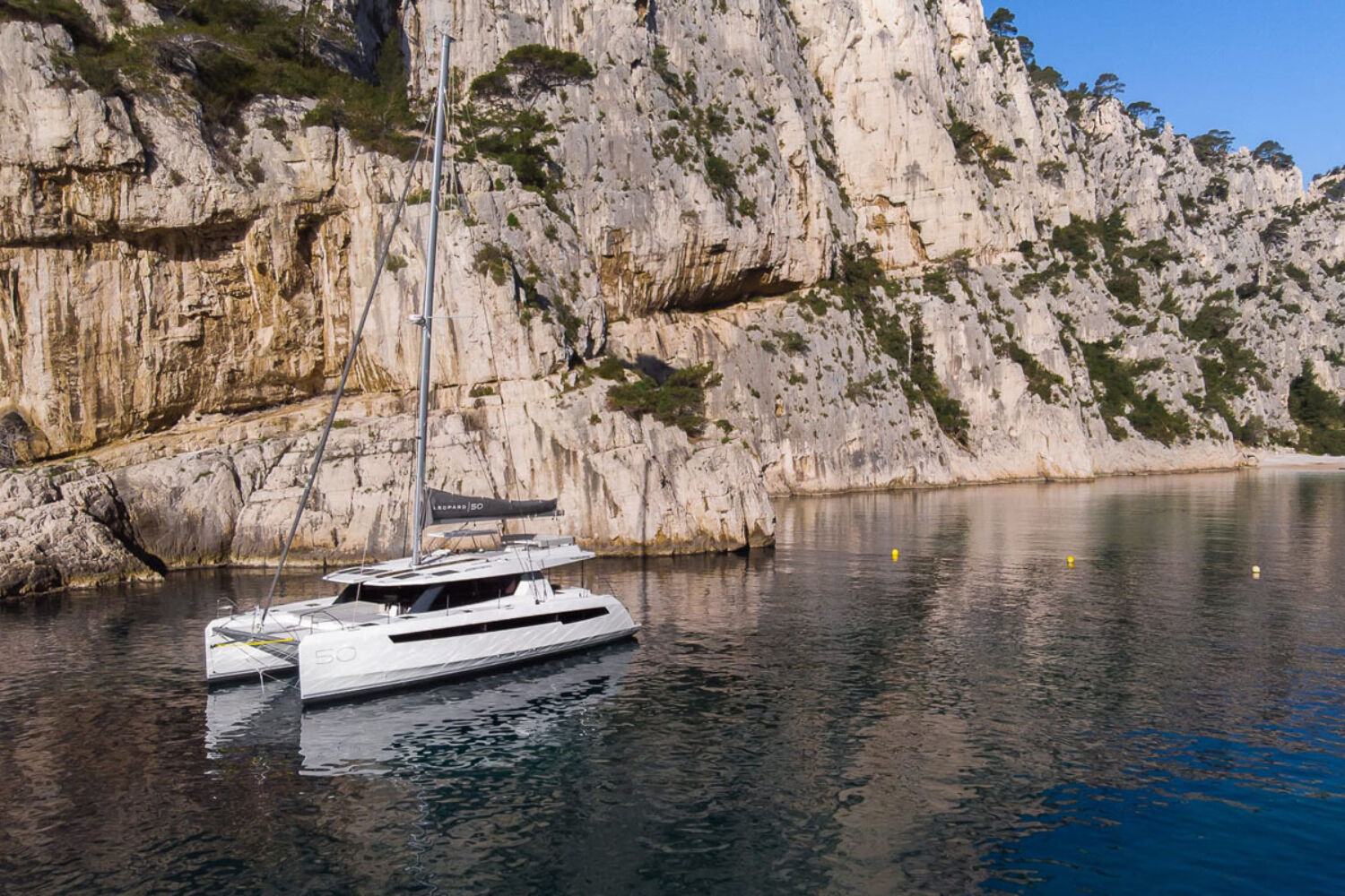 Eclipse Expeditions Leopard 50 at anchor by a cliff